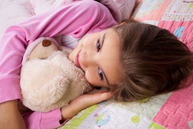 küçük bir kız yatakta yatıyordu
