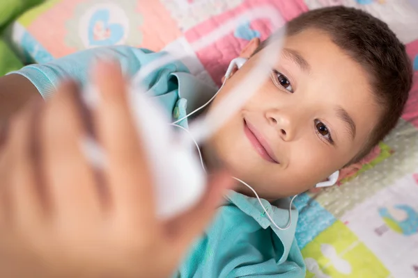 Happy boy listening to music in bedroom — Stock Photo, Image