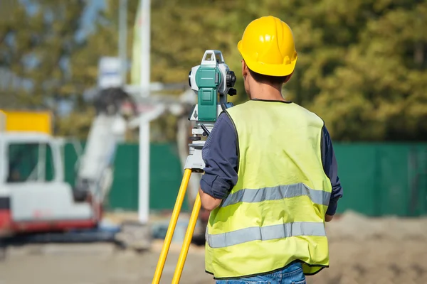 Ingenieros topógrafos trabajando con teodolito en obras de construcción de carreteras —  Fotos de Stock