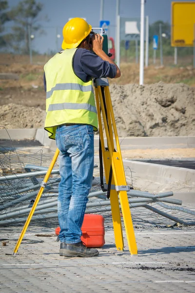 Engenheiros de vistoria que trabalham com teodolite em canteiros de obras rodoviárias — Fotografia de Stock