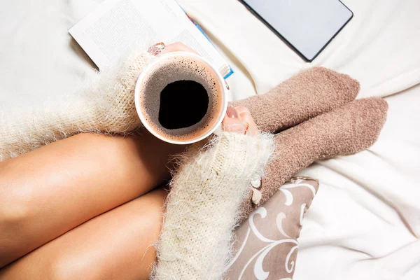 Vacker ung kvinna som sitter i sängen med kopp kaffe — Stockfoto