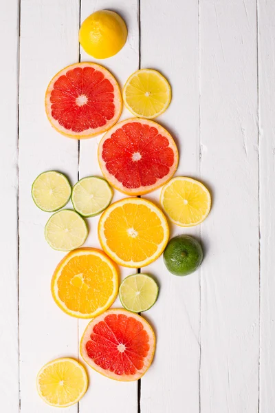 Cytryny, mandarynki, pomarańczowe i różowe grejpfruty białe drewno — Zdjęcie stockowe
