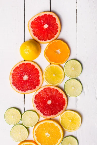 Cytryny, mandarynki, pomarańczowe i różowe grejpfruty białe drewno — Zdjęcie stockowe