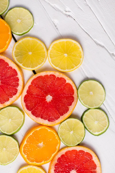 Toranja limão, tangerina, laranja e rosa sobre madeira branca — Fotografia de Stock