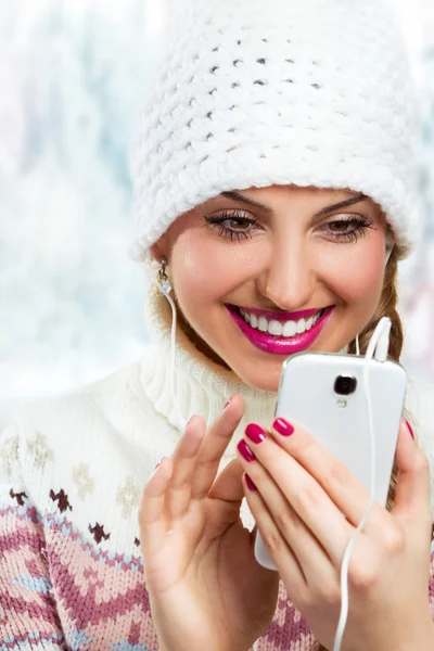 Téli lány hallgat zenét, a telefon használata — Stock Fotó