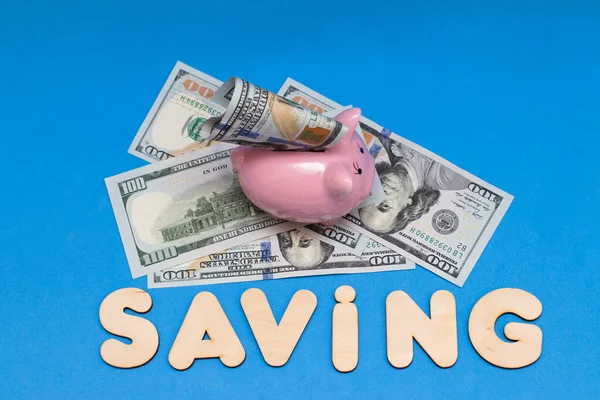 豚の貯金箱と青い背景の単語を保存します お金の節約 — ストック写真