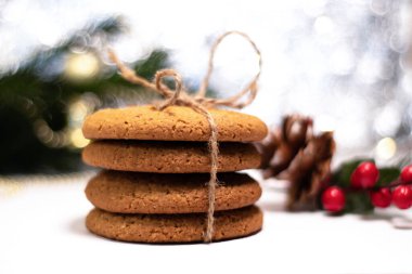 Arka planda bir yığın yulaflı kurabiye. Noel süslemeleri ve bokeh. Noel ve Yeni Yıl için sevdiklerinize hediyeler.