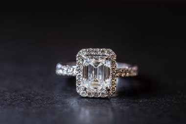 Büyük beyaz mücevherli gümüş yüzük ve siyah arka planda küçük elmaslar.