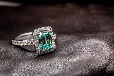 Kare şeklindeki yeşil taşlı gümüş yüzük desenli deri arka plan