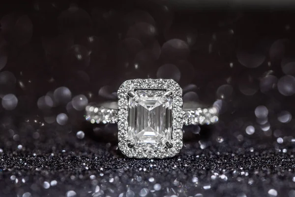 Üzerinde büyük mücevher ve küçük elmaslar olan gümüş yüzüklü siyah beyaz fotoğraf.