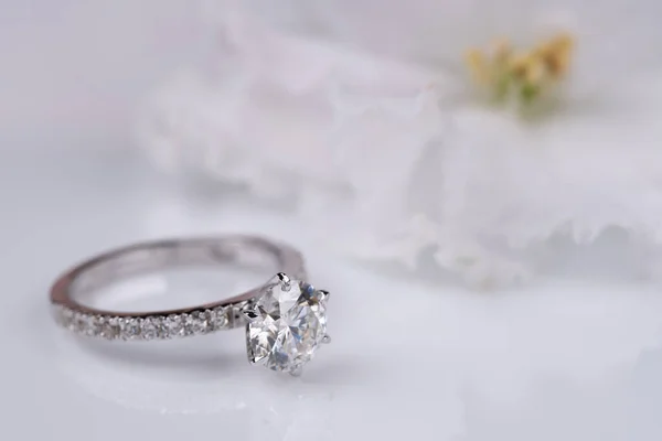 Beyaz arkaplanda çiçekli nişan yüzüğü.