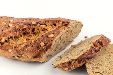 Beyaz arkaplanda susam tohumlu dilimlenmiş ekmek