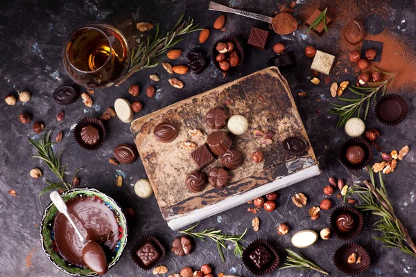 chocolate truffles with nuts and spices on a dark background.