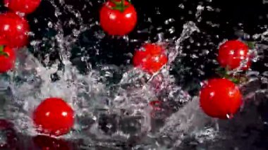 Kiraz domatesleri ve siyah arka planda su. Yemek konsepti. Boşluğu kopyala.