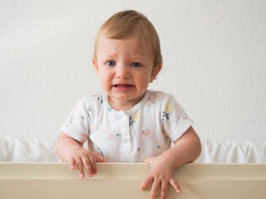 Crying caucasian baby girl in bed