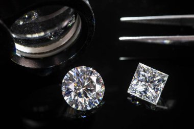 Cımbızlı lüks elmaslar ve siyah arkaplanlı loupe. 