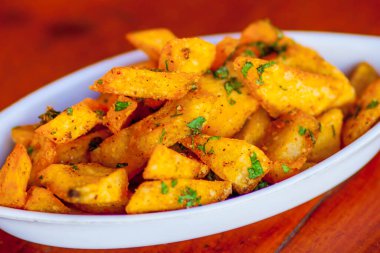 Baharatlı ve otlu ev yapımı patates dilimleri.