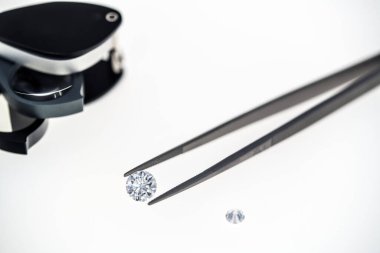 Elmas, cımbız ve beyaz arka plan üzerinde büyüteç 