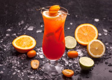 Koyu arkaplanda buz küpleri ve limonlu bir bardak soğuk içecek.