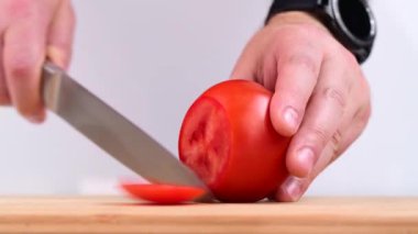 Kesme tahtasından taze domates kesiliyor