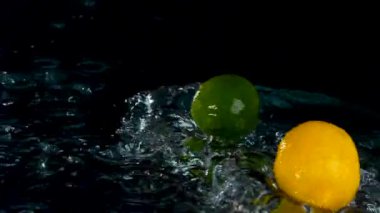 Taze limon ve limon yakın plan siyah zemin üzerinde süzülen su 