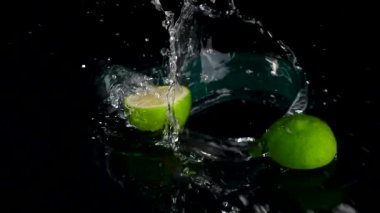 Siyah zemin üzerinde suyla sıçrayan taze limonlara yakın çekim 