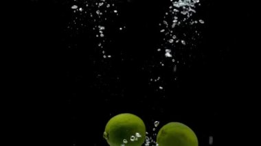 Siyah arkaplanda taze yeşil limon