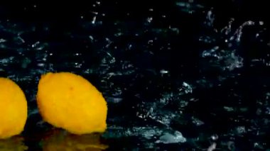 Siyah zemin üzerinde suyla süzülen taze limonlara yakın çekim 