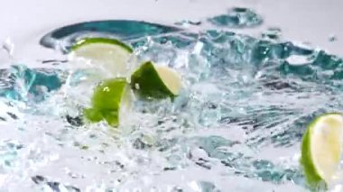 Beyaz arka planda suyla su sıçrayan taze limonlara yakın çekim 