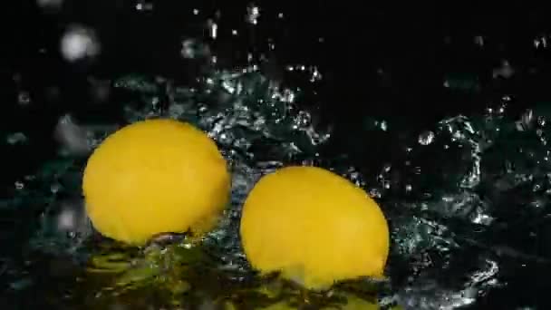 Крупный План Свежих Лимонов Плескающихся Водой Черном Фоне — стоковое видео