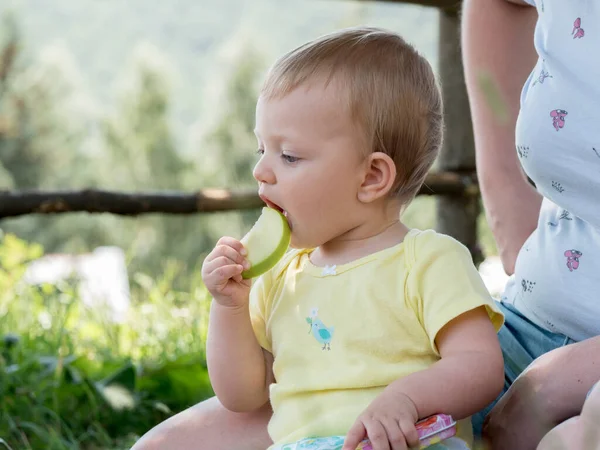Cute Caucasian Baby Girl Eating Apple Piece Mother Arms — Fotografia de Stock