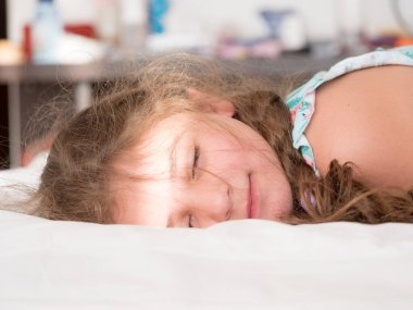 Caucasian little girl sleeping in bed