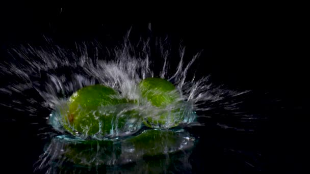 Close Van Verse Limoenen Spatten Door Water Zwarte Achtergrond — Stockvideo