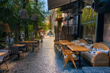 Erivan, Ermenistan 10.16.2025. Restoranın dışında masa ve sandalyelerle dolu bir kaldırım. Masalar beyaz bezlerle kaplı ve sandalyeler ahşap. Sandalyeler sokağa bakacakları şekilde dizilmiş.