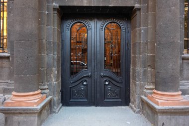 Bir binanın ön kapısı siyahtır ve üzerinde 