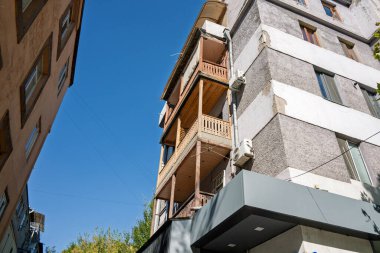 Erivan, Ermenistan 10.16.2025. Balkonu ve beyaz duvarı olan bir bina. Balkon ahşap ve gökyüzü manzaralı.