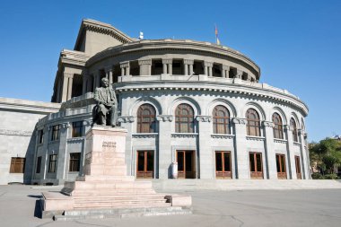 Erivan, Ermenistan 10.16.2025. Üzerinde bir adamın heykeli olan büyük bir opera binası. Bina gri ve bir sürü penceresi var.
