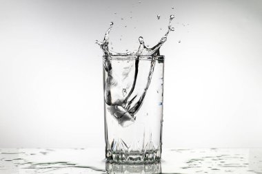 İçinde buz olan bir bardak su bardaktan su sıçratıyor. Su soğuk ve ferahlatıcı, ve buz küpleri eriyor, bir sıçrama yaratıyor. Hareket ve enerji kavramı