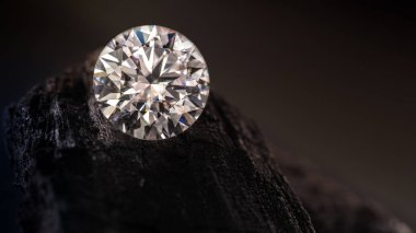 Bir kayanın üzerinde bir elmas duruyor. Elmas ilgi odağı ve kaya da arka plan.