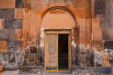 Eski Hovhannavank manastırı kapısı sarıdır ve üzerinde haç vardır. Kapı açık ve içerisi karanlık.