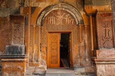 Eski manastır kapısı açık ve bina eski. Kapı ahşap ve üzerinde bir sürü oyma var.