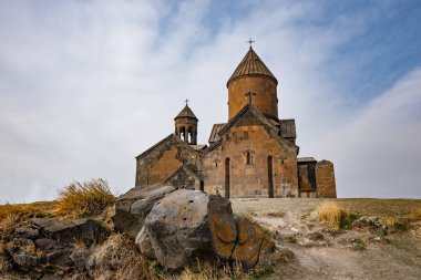 Çan kulesi ve haçı olan bir Ermeni Saghmosavanq manastırı. Bina kayalık bir yamaçla çevrili.