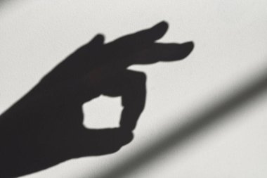 Bir el gölgede baş parmak hareketi yapıyor. Pozitiflik ve onay kavramı