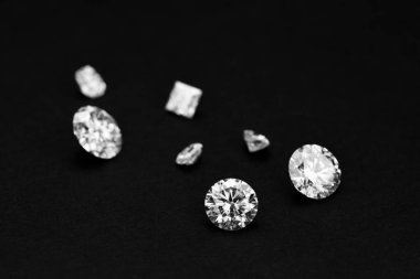 Çeşitli elmasların olduğu siyah bir arkaplan. Elmasların şekilleri ve boyutları farklı ve hepsi beyaz. Lüks ve zarafet kavramı