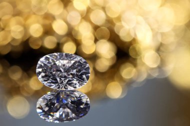 Bulanık bir arkaplanı olan bir masanın üzerinde bir elmas oturuyor. Elmas görüntünün odak noktasıdır ve sahnedeki en önemli şeydir.