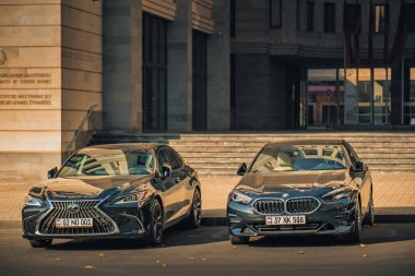 İki araba Lexus ve BMW yan yana park edilmiş..