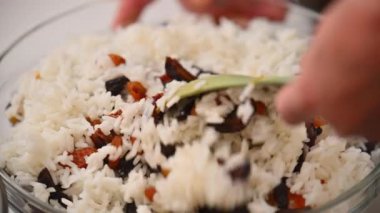 Bir kadın Ermeni yemeği hazırlamak için pirinç ile kurutulmuş meyveyi karıştırıyor.