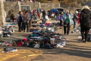 Bir grup insan bit pazarında yürüyor. Sahne kaotik ve düzensiz.