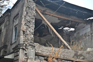 Çatısı kocaman bir delik olan bir bina. Bina harabe halinde. Çatı kayıp ve duvarlar yıkılıyor. Bina bakımsız durumda.