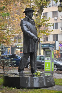 Alexander Mantashev 'in bir heykeli. Şapka takıyor ve baston tutuyor. Heykel bir parkmetre ve bir araba ile çevrili.